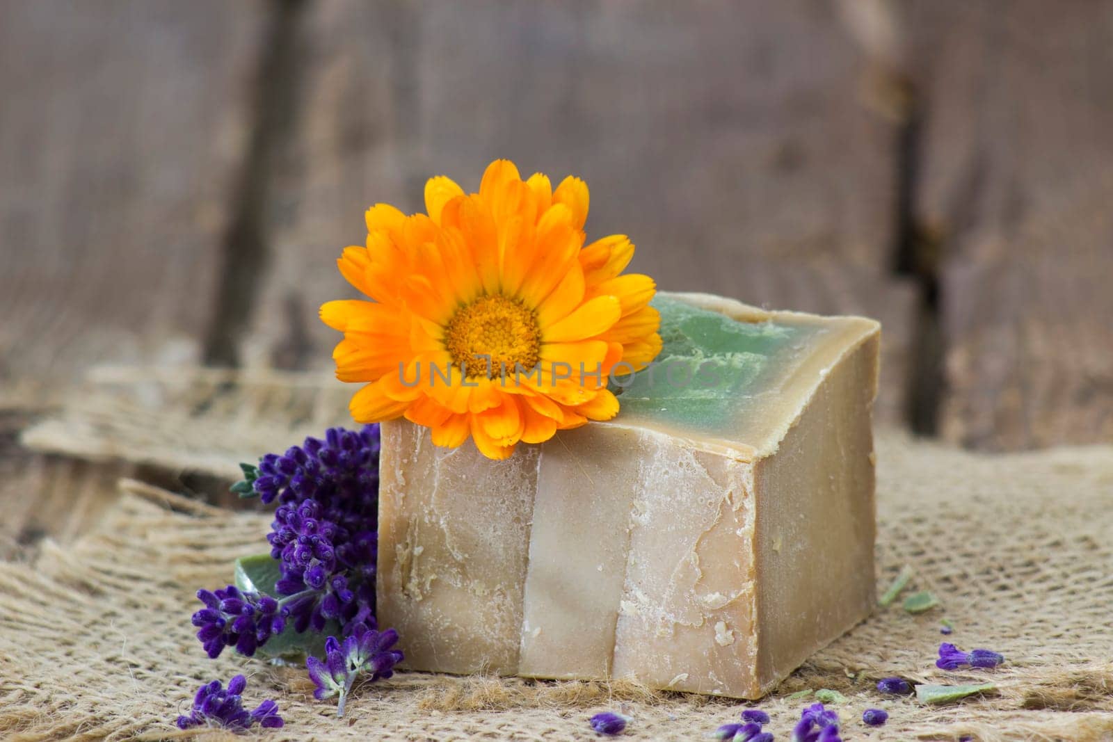 Natural handmade soap with calendula and lavender on old rustic background