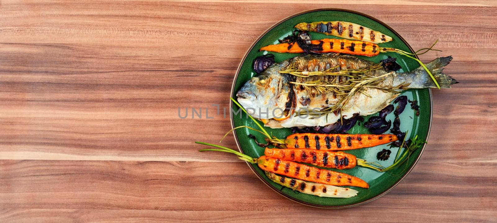 Baked dorado fish or sea bream with grilled vegetables on concrete background. Flat Lay