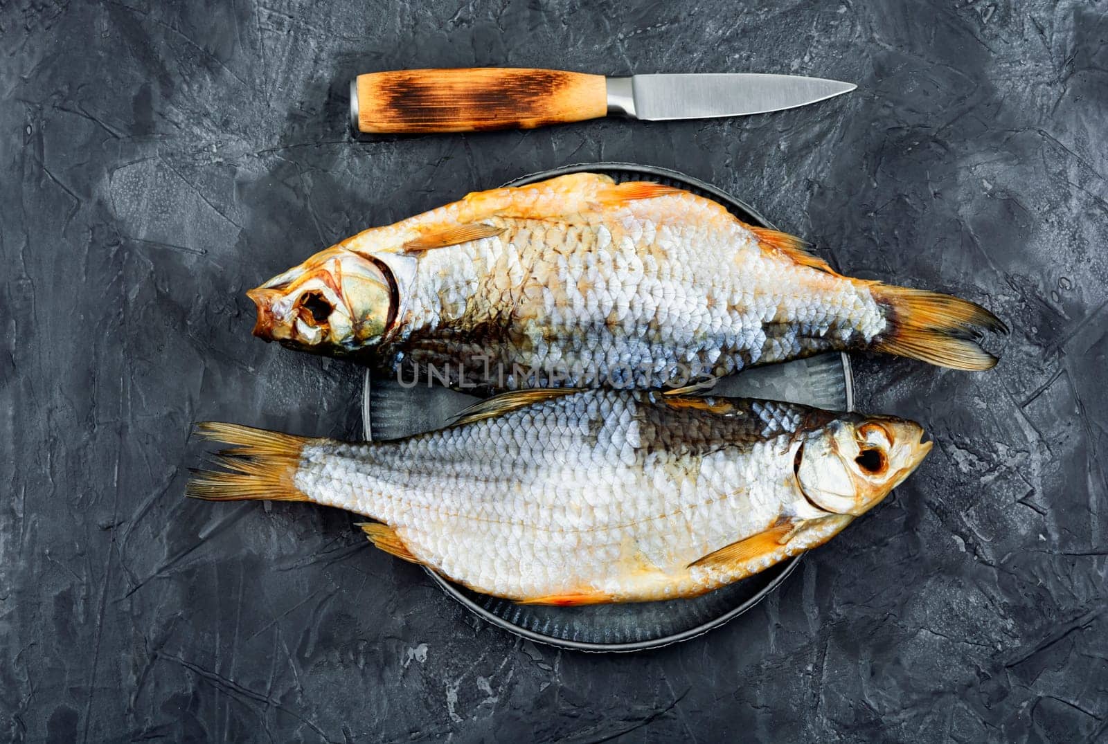Whole dried salted fish on the table. Stockfish. Top view.
