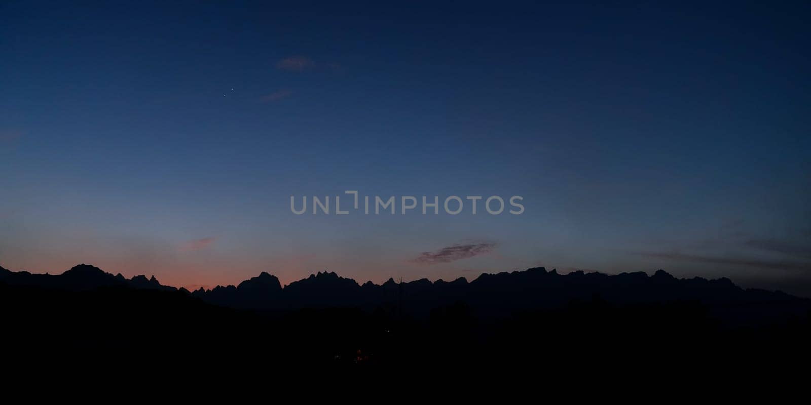Silhouettes of low desert mountains with blue sky just after sunset - Venus and Jupiter visible - typical evening landscape near Yanbu, Saudi Arabia.