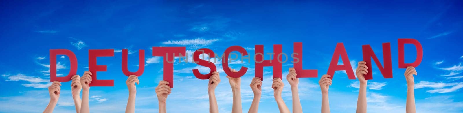 People Or Persons Hands Building German Word Deutschland Means Germany. Blue Sky As Background.