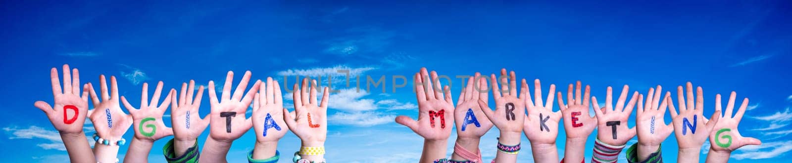 Children Hands Building Colorful English Word Digital Marketing. Blue Sky As Background.