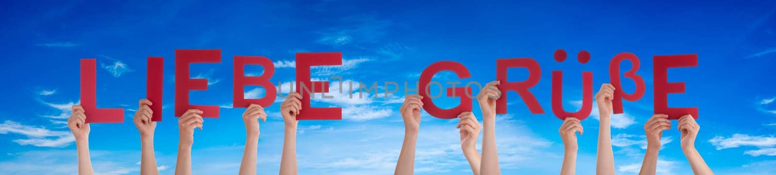 People Or Persons Hands Building German Word Liebe Gruesse Means Many Greetings. Blue Sky As Background.