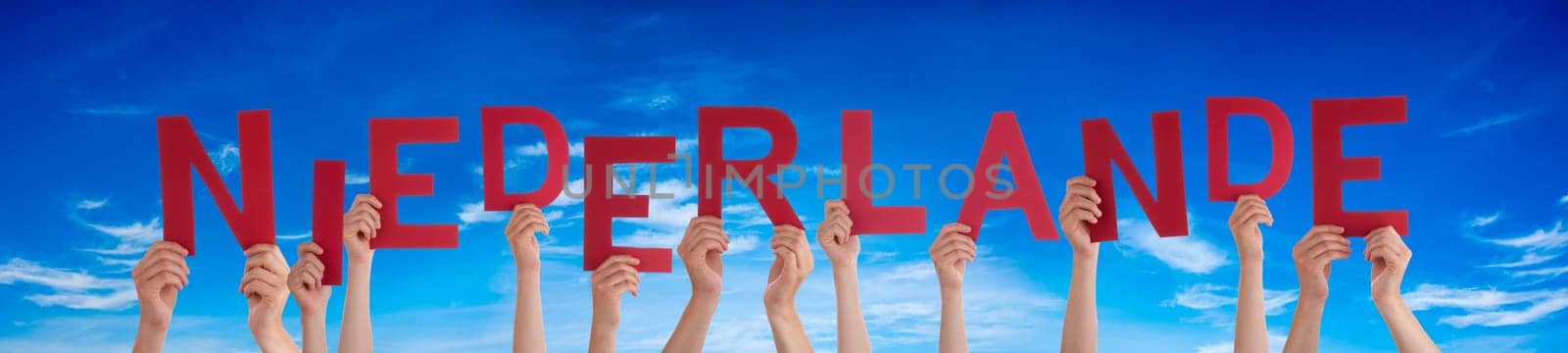 People Or Persons Hands Building German Word Niederlande Means Netherlands. Blue Sky As Background.