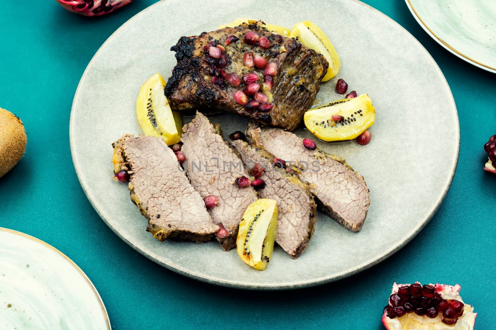 Cooked veal meat in kiwi and pomegranate sauce.