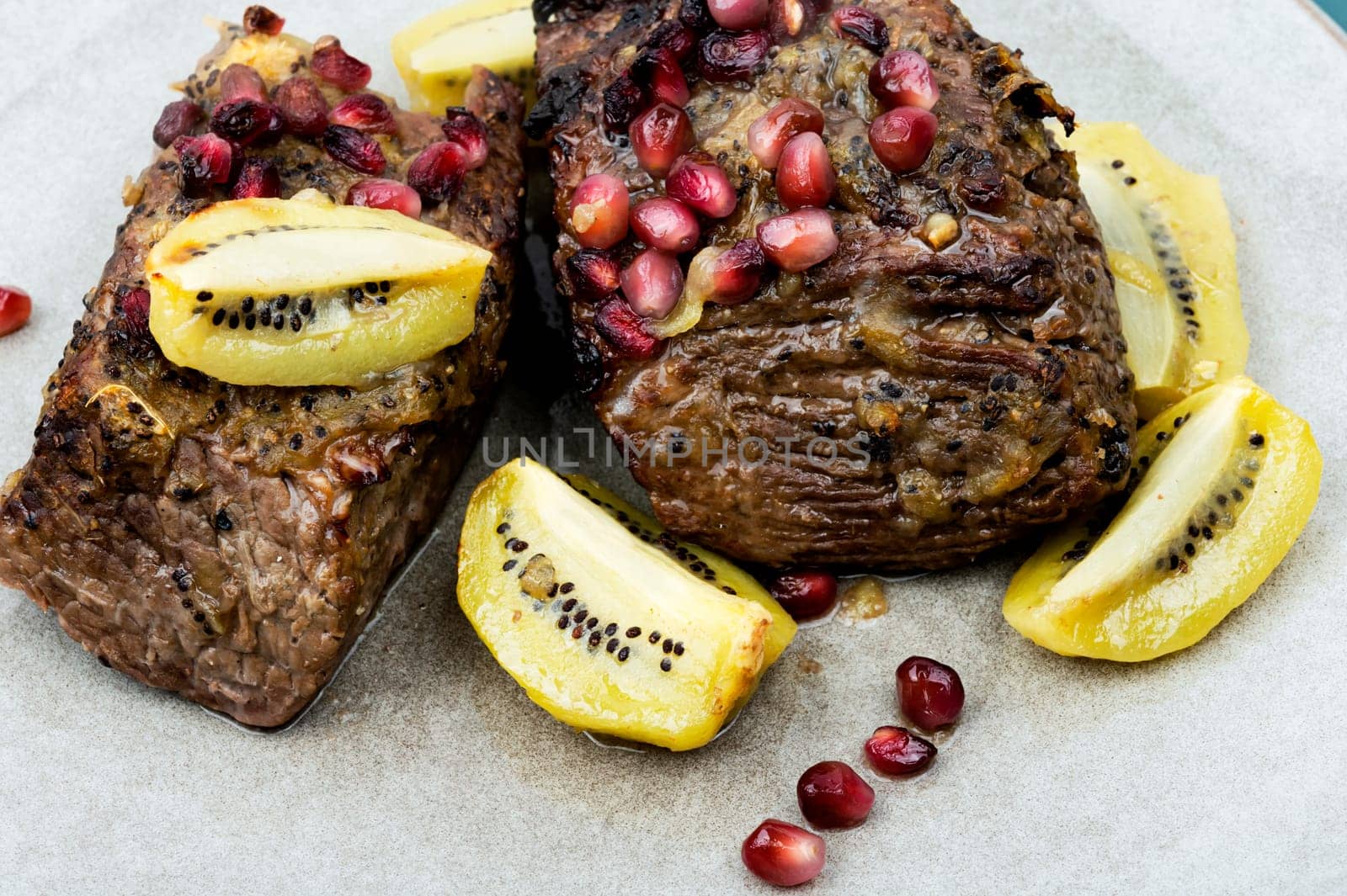 Cooked veal meat in kiwi and pomegranate sauce.