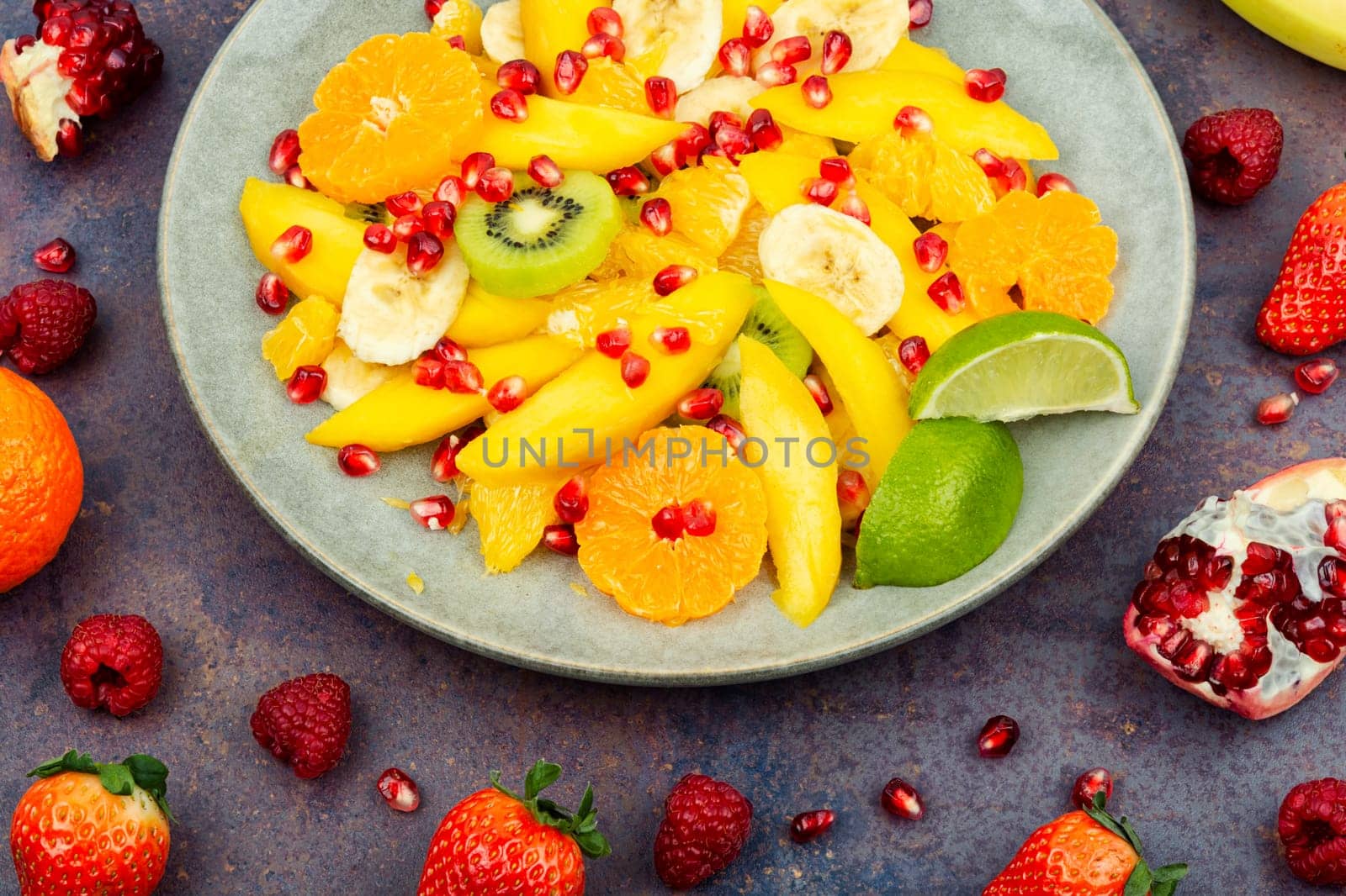Fresh salad of mango, citrus, banana and ripe berries. Top view