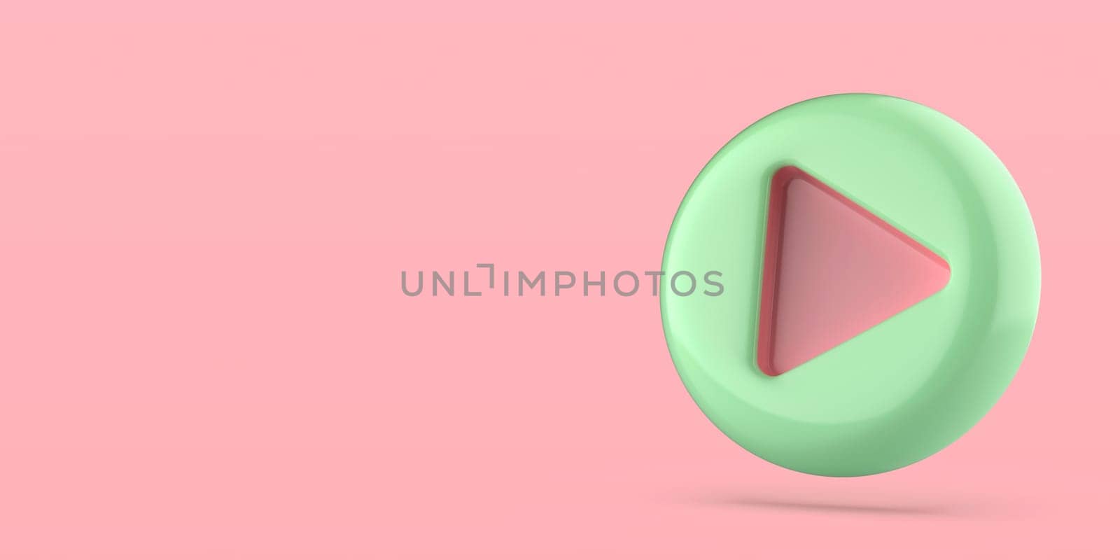 Green plastic play button on pink background