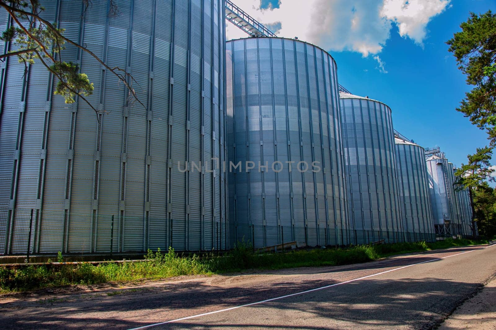 Industrial vertical stainless steel liquid tanks outdoors. Metal tank for liquid. Stainless steel tank. Industrial equipment of the enterprise. Food industry. Production cycle.