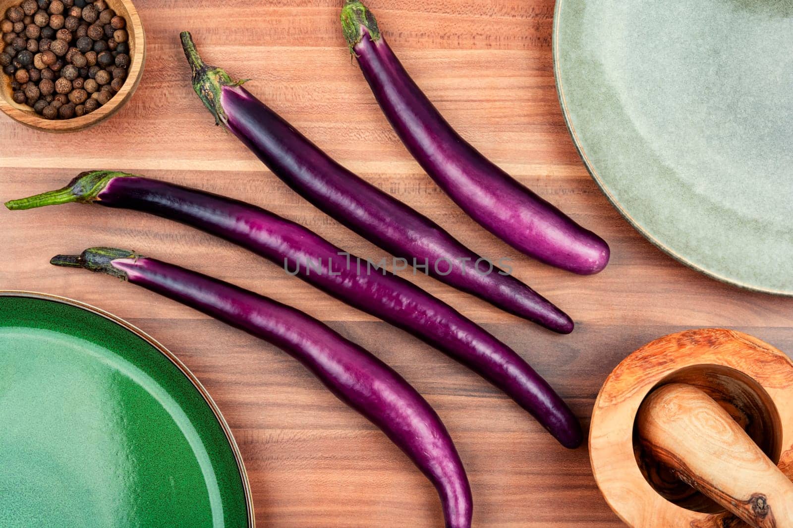 Raw small eggplants on a wooden table. Diet menu concept. Top view