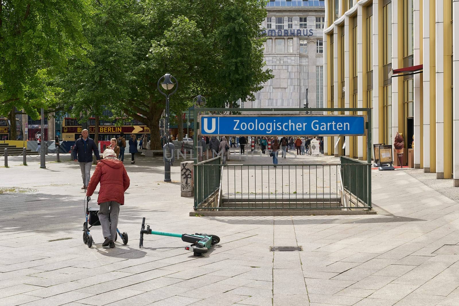 lying e-scooter and elderly woman at subway station Zoologischer Garten at Breitscheidplatz in Berlin