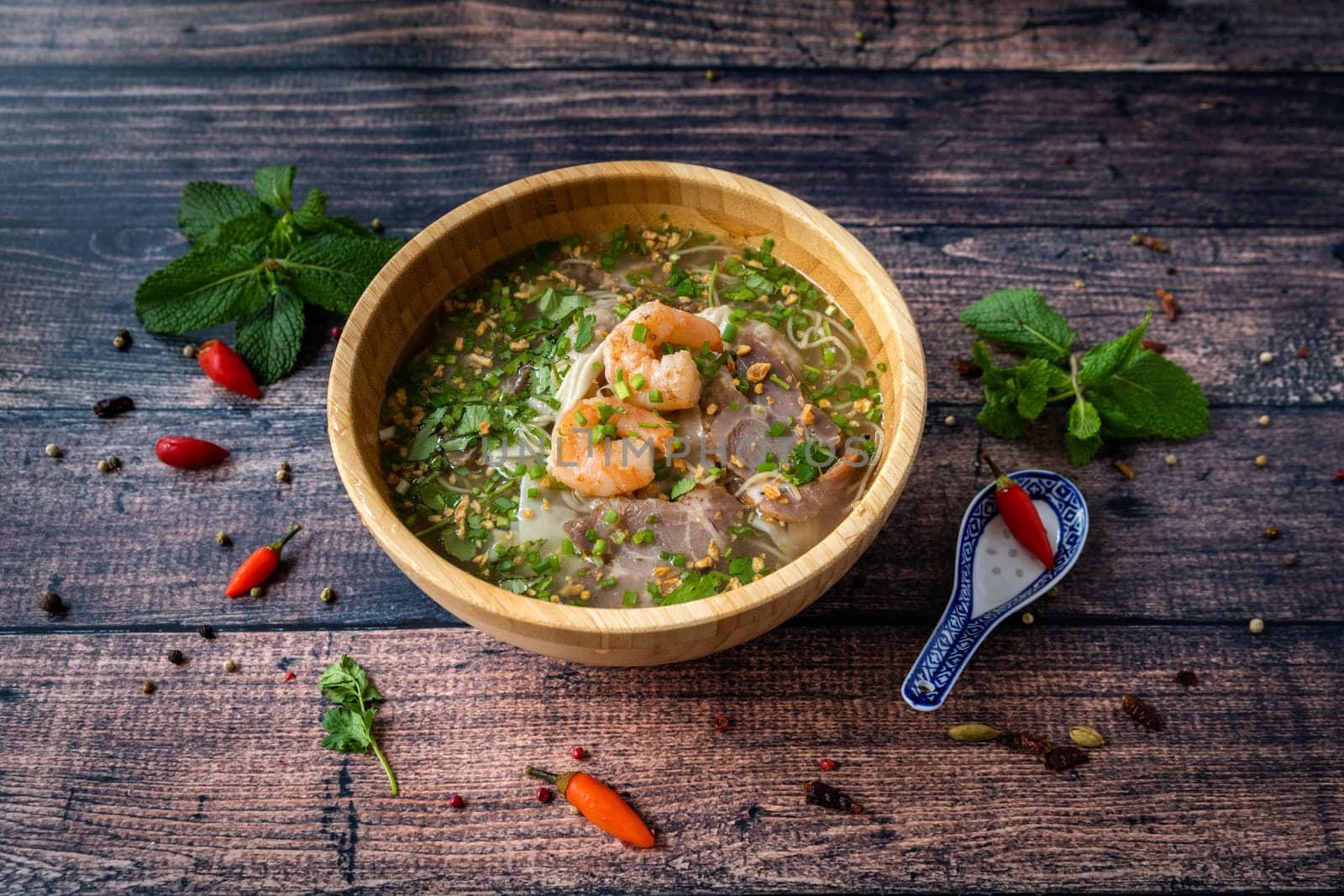 Vietnamese specialty : ravioli soup in a bowl and placed on a wooden table