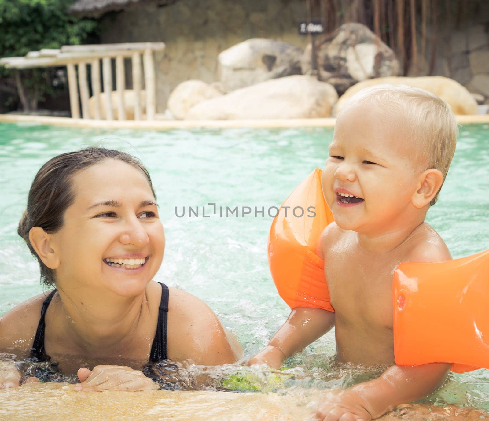 Baby and mother in swimming pool