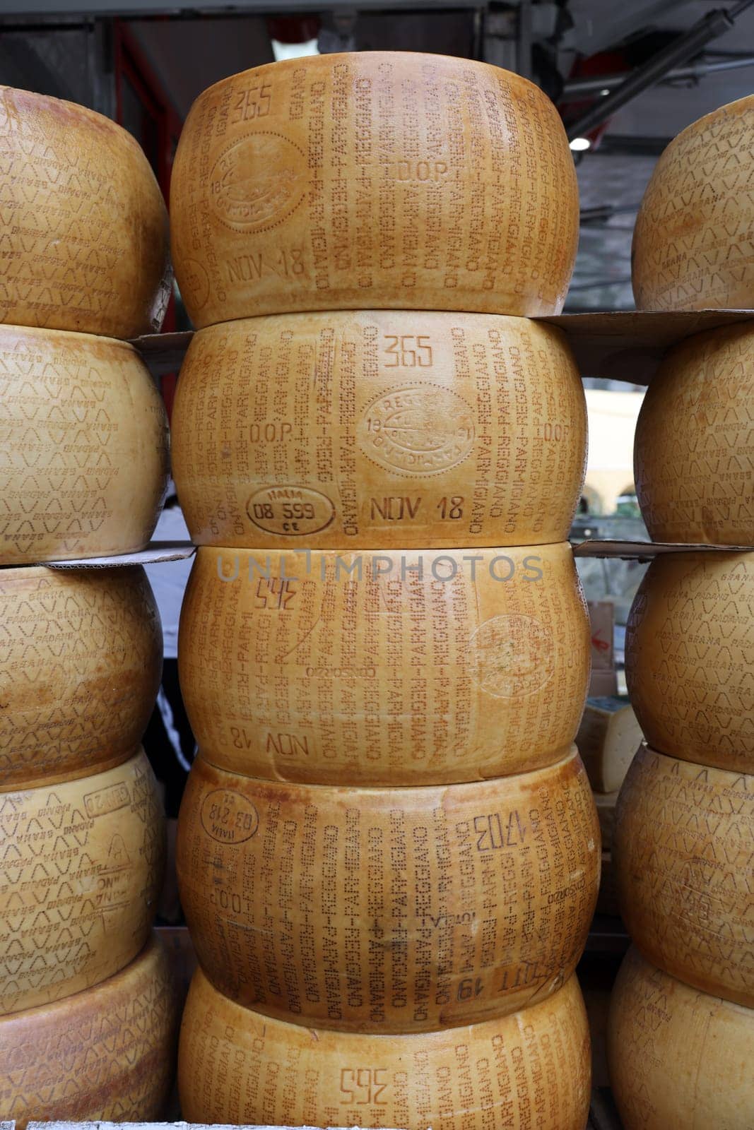 Cremona, Italy - September 7, 2022: Whole wheels of Parmigiano Reggiano cheese sold at a street stall during the farmers market in Cremona, Lombardy, Italy