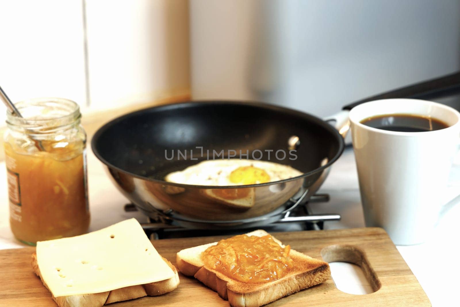 Breakfast served on the kitchen table with a fried egg on a plate and fresh bread and coffee. High quality photo
