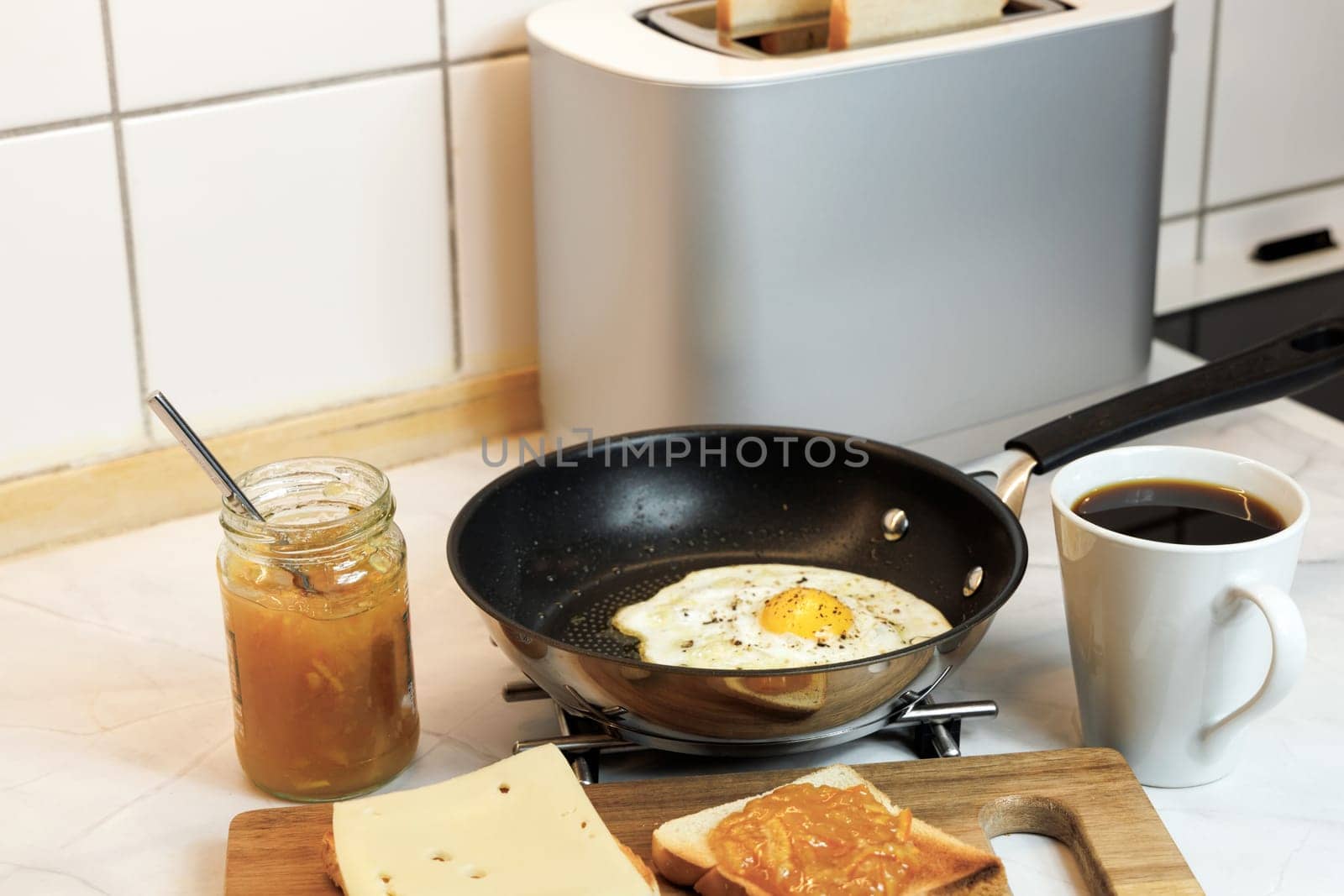 Breakfast served on the kitchen table with a fried egg on a plate and fresh bread and coffee. High quality photo