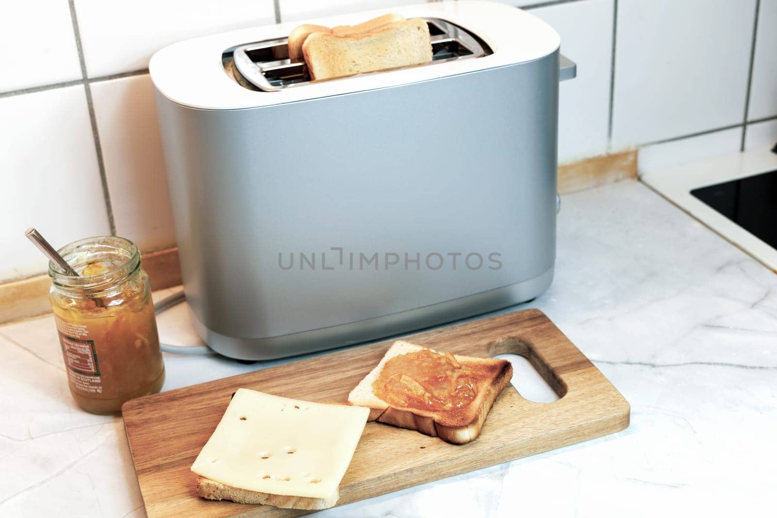 Breakfast served on the kitchen table with fresh toast bread and jam. High quality photo