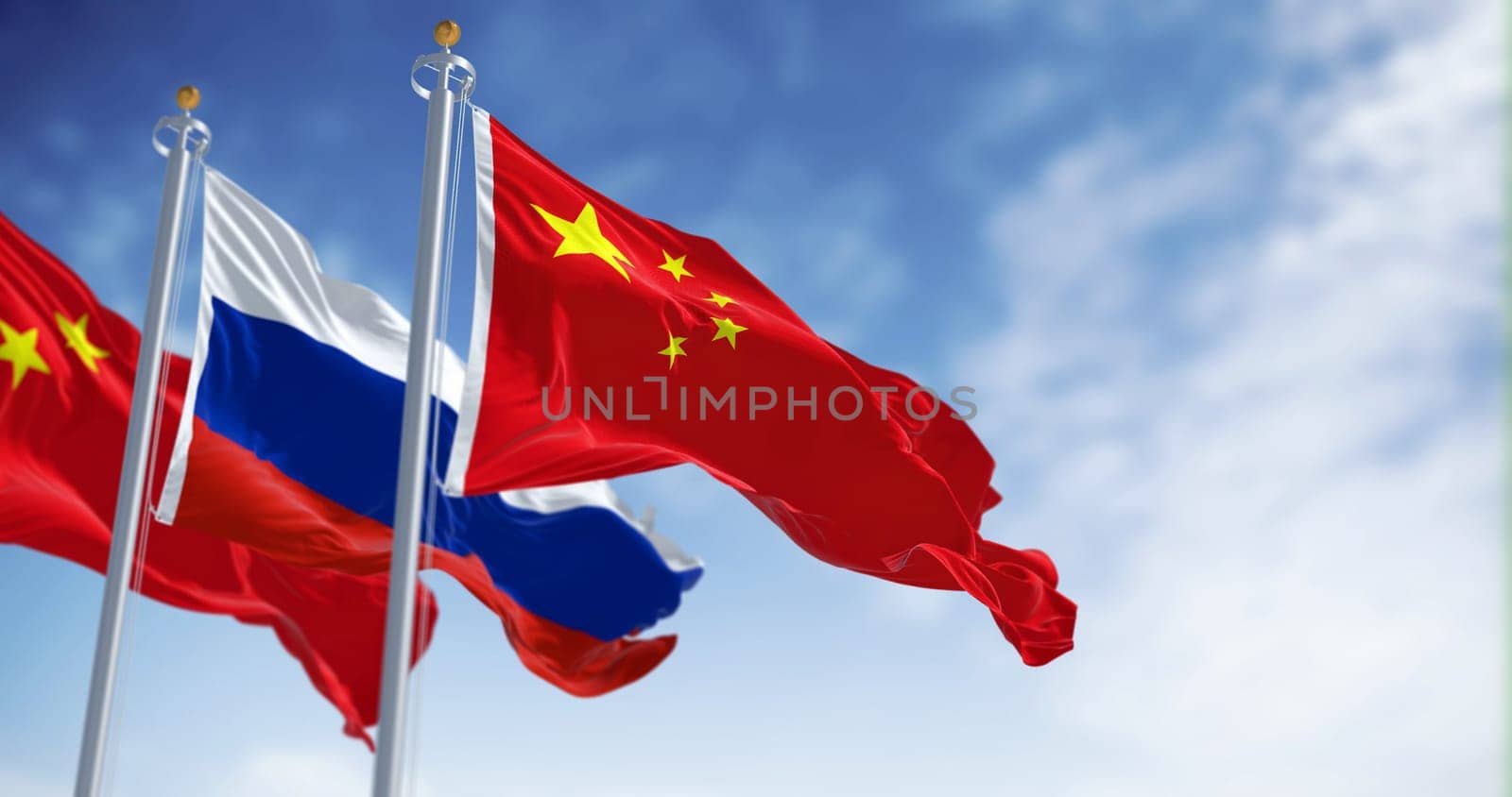 The flags of China and Russia waving in the wind on a clear day. International relations and diplomacy. 3d illustration render. Selective focus. Fluttering textile