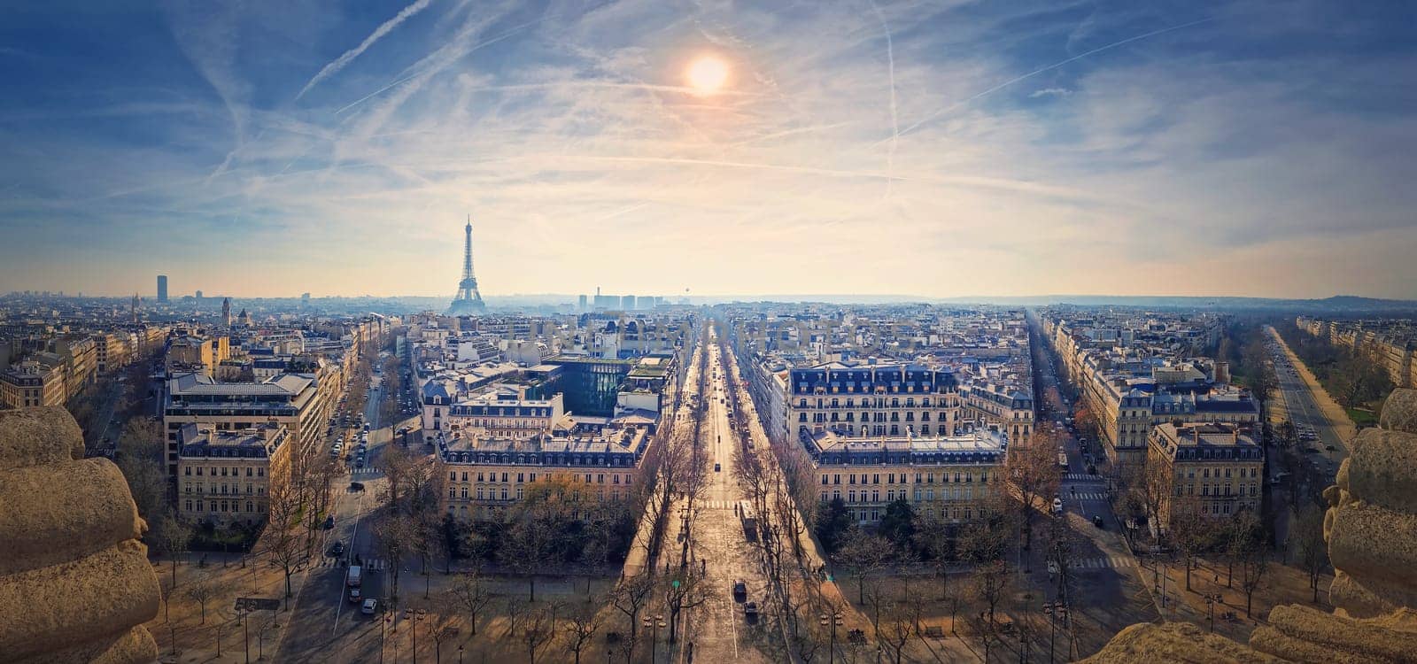Wide angle Paris cityscape panorama with view to the Eiffel Tower, France. Beautiful parisian architecture with historic buildings, landmarks and busy city streets.