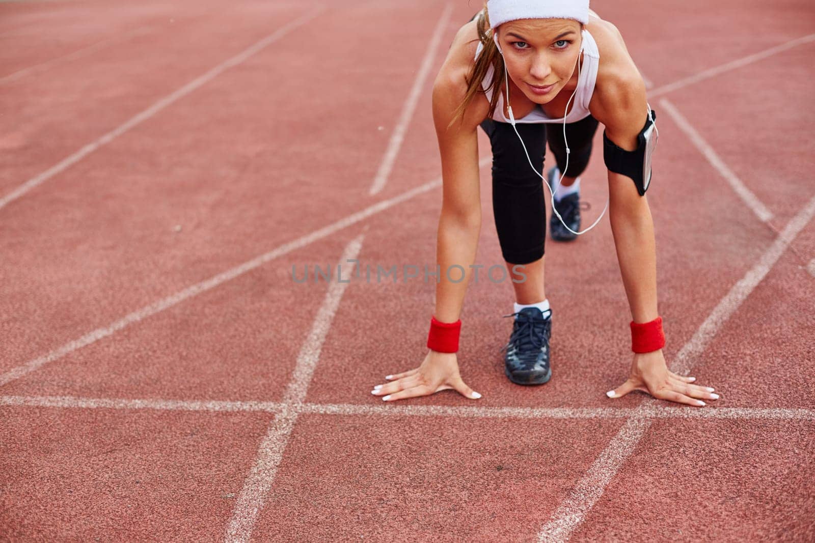 Fit girl in activewear standing at start line ready to run