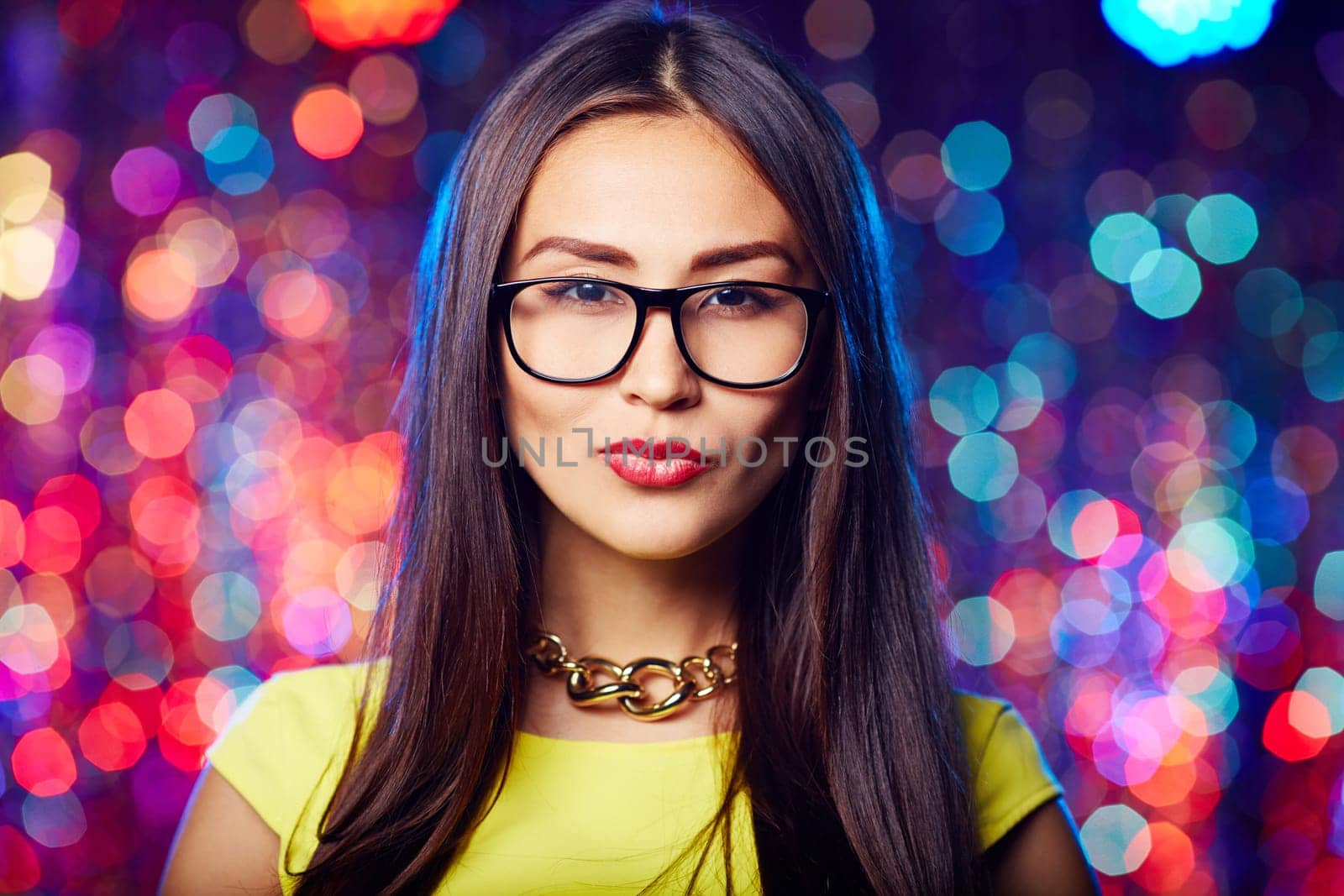 Asian girl in eyeglasses and perfect makeup looking at camera