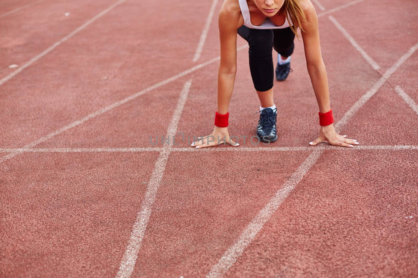 Sporty female on racetrack ready to run
