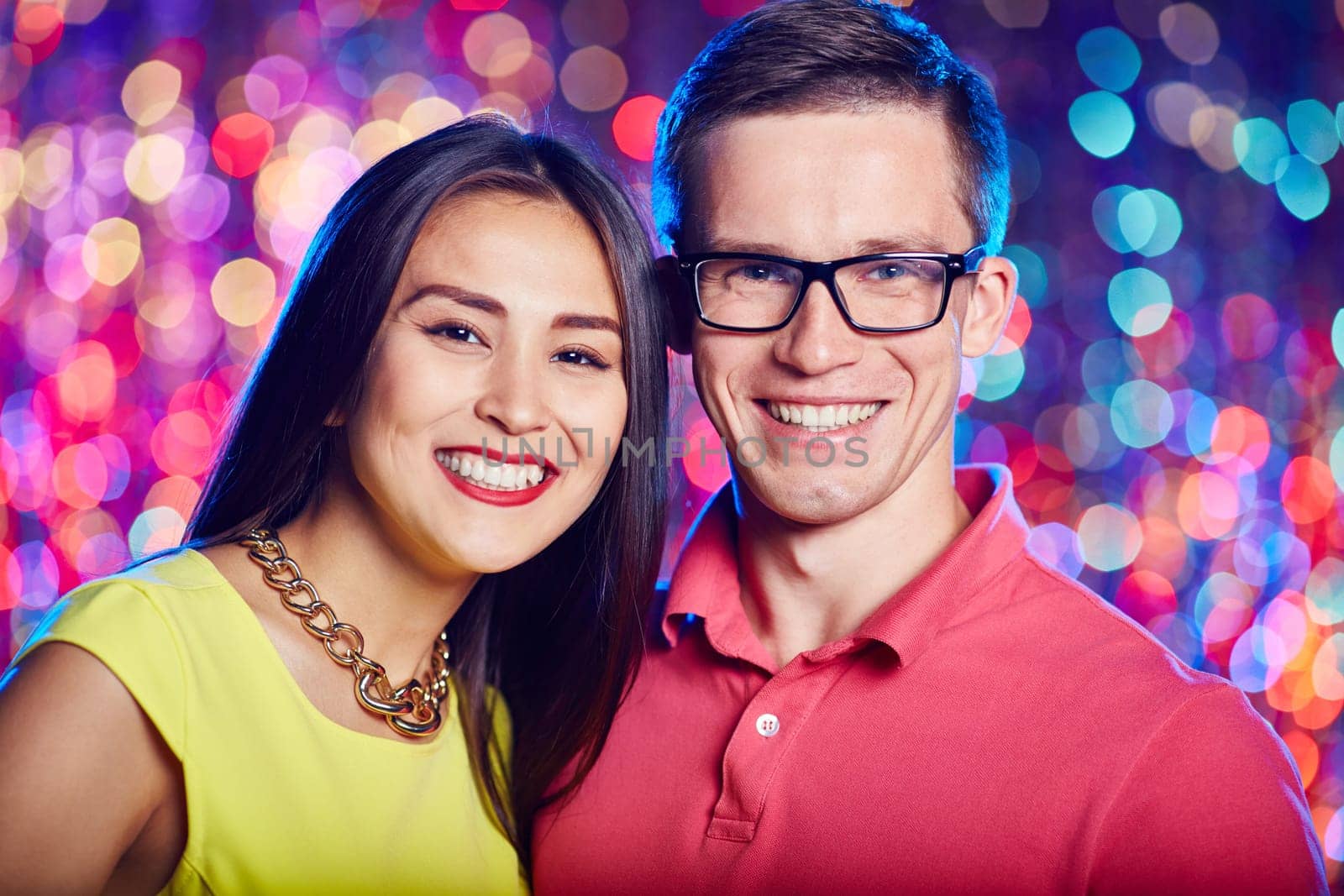 Cheerful couple looking at camera at party in nightclub