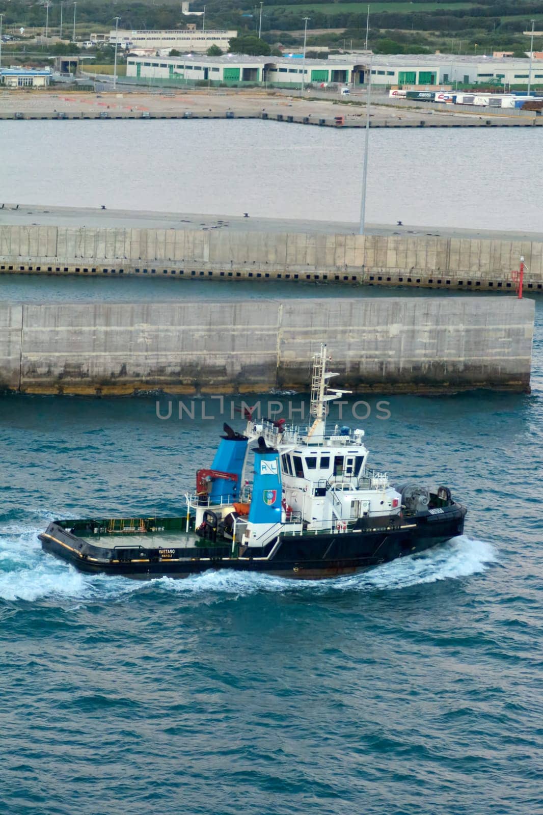 Civitavecchia, Italy - February 18, 2025: Tugboat Vastaso, registered in Naples, sails near port. Detailed view of its industrial design and maritime functionality. Transport and industry topics.