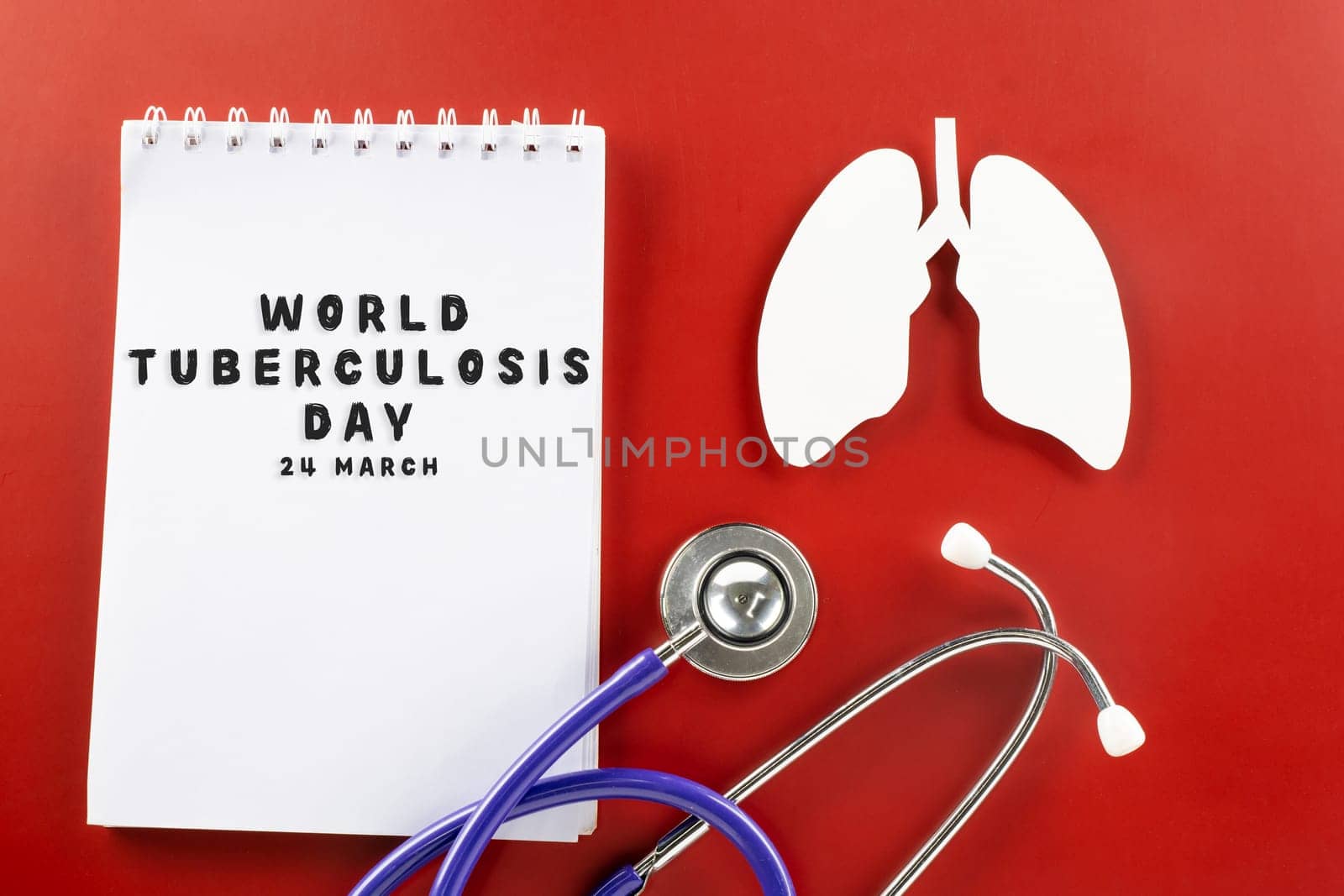 World Tuberculosis Day. Overhead lungs paper symbol, medical stethoscope and notebook paper on red background, lung cancer awareness, copy space concept of world TB day