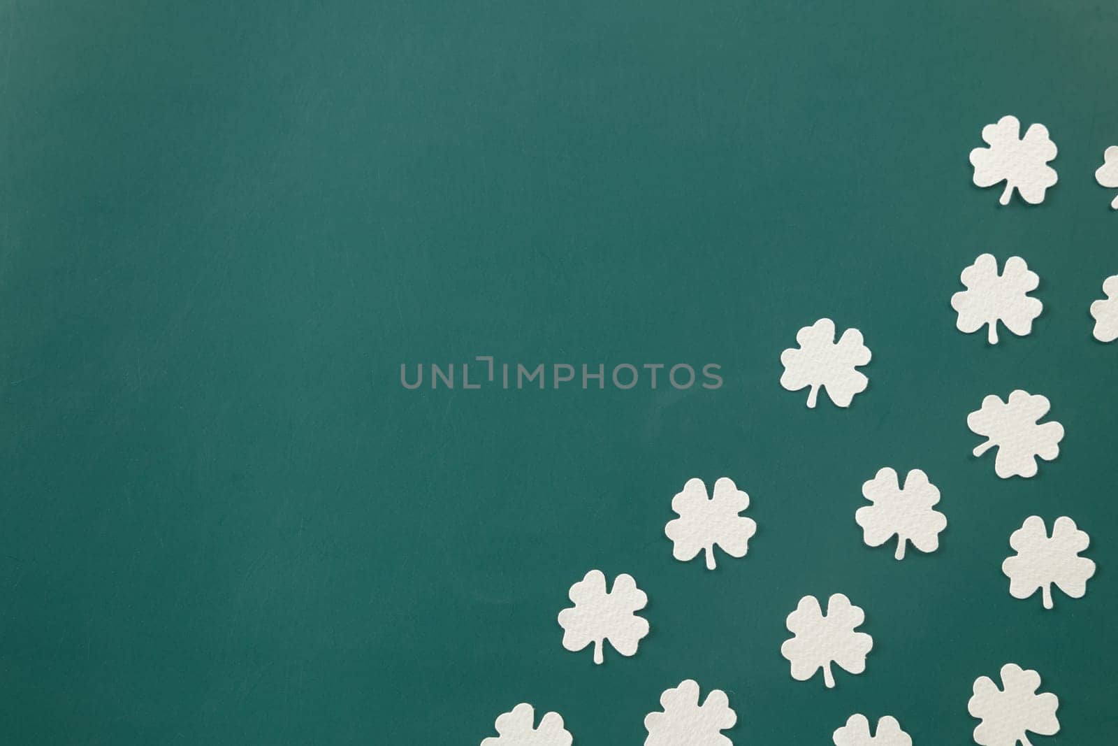 Happy St Patricks Day decoration background. above top view of paper clover leaves festive decor, shamrocks leaves holiday symbol with copy space on colour background, Banner greeting card concept