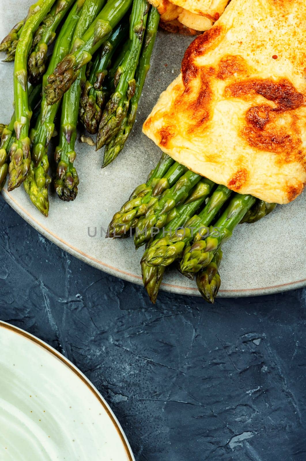 Egg omelet cooked with green asparagus on rustic wooden table