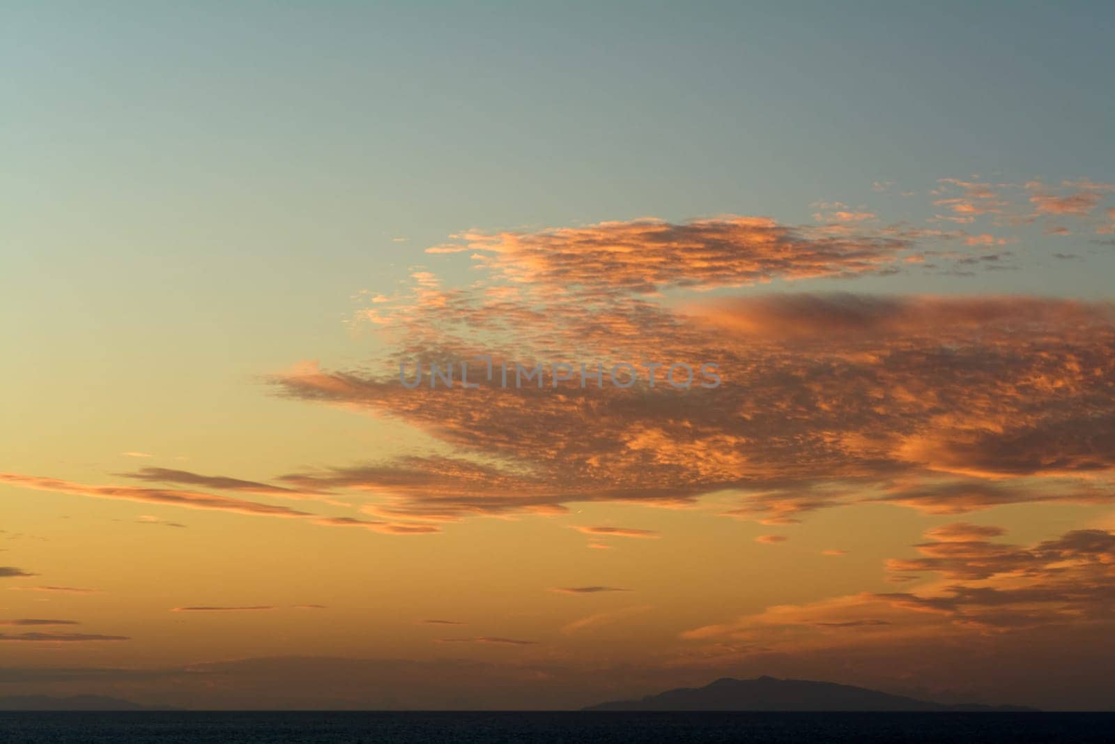 A stunning display of clouds at sunset, with orange and yellow hues illuminating the horizon, creating a serene and peaceful atmosphere. Ideal for nature and landscape content.