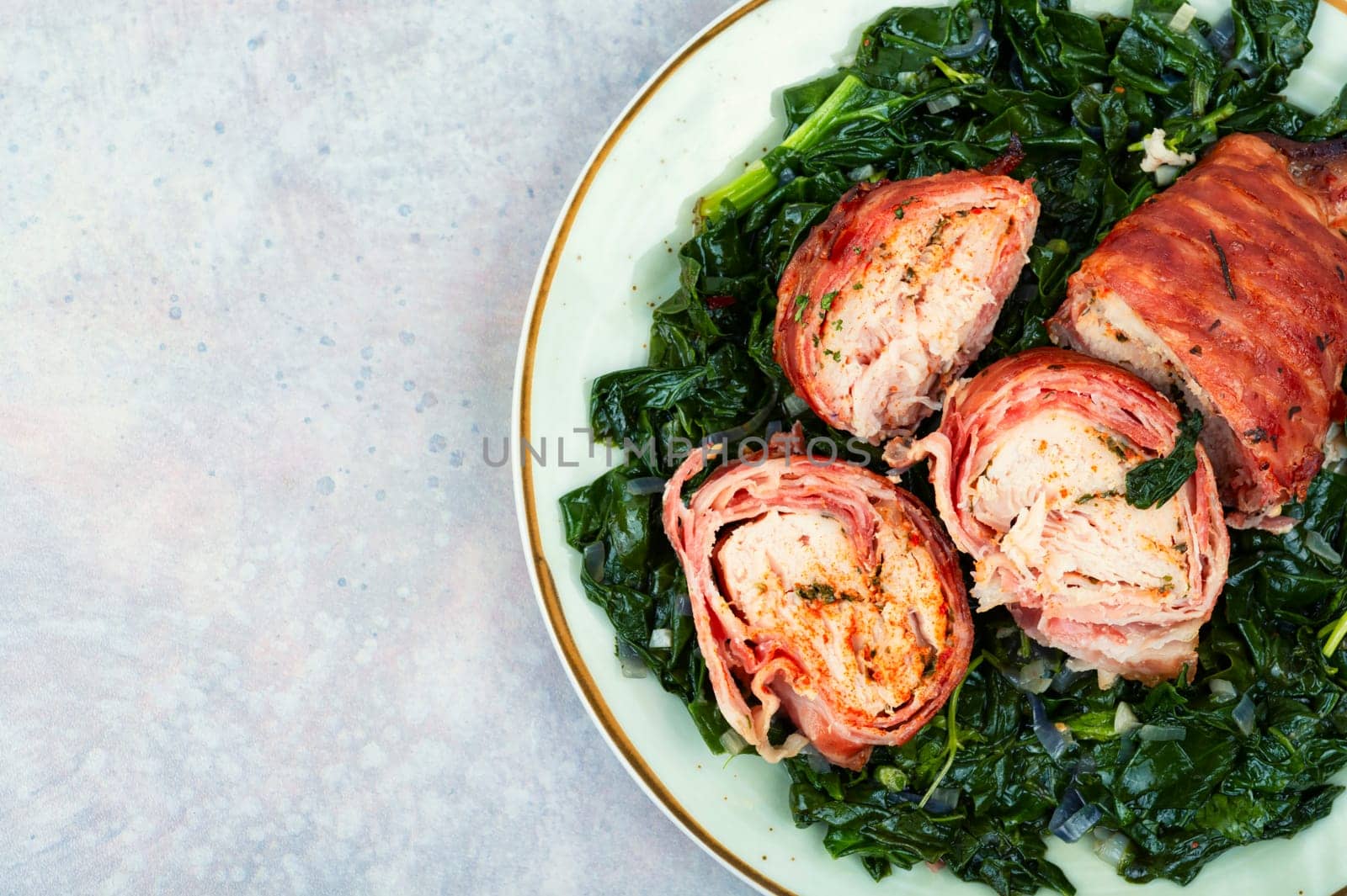 Grilled chicken fillet roll and fried spinach. Copy space