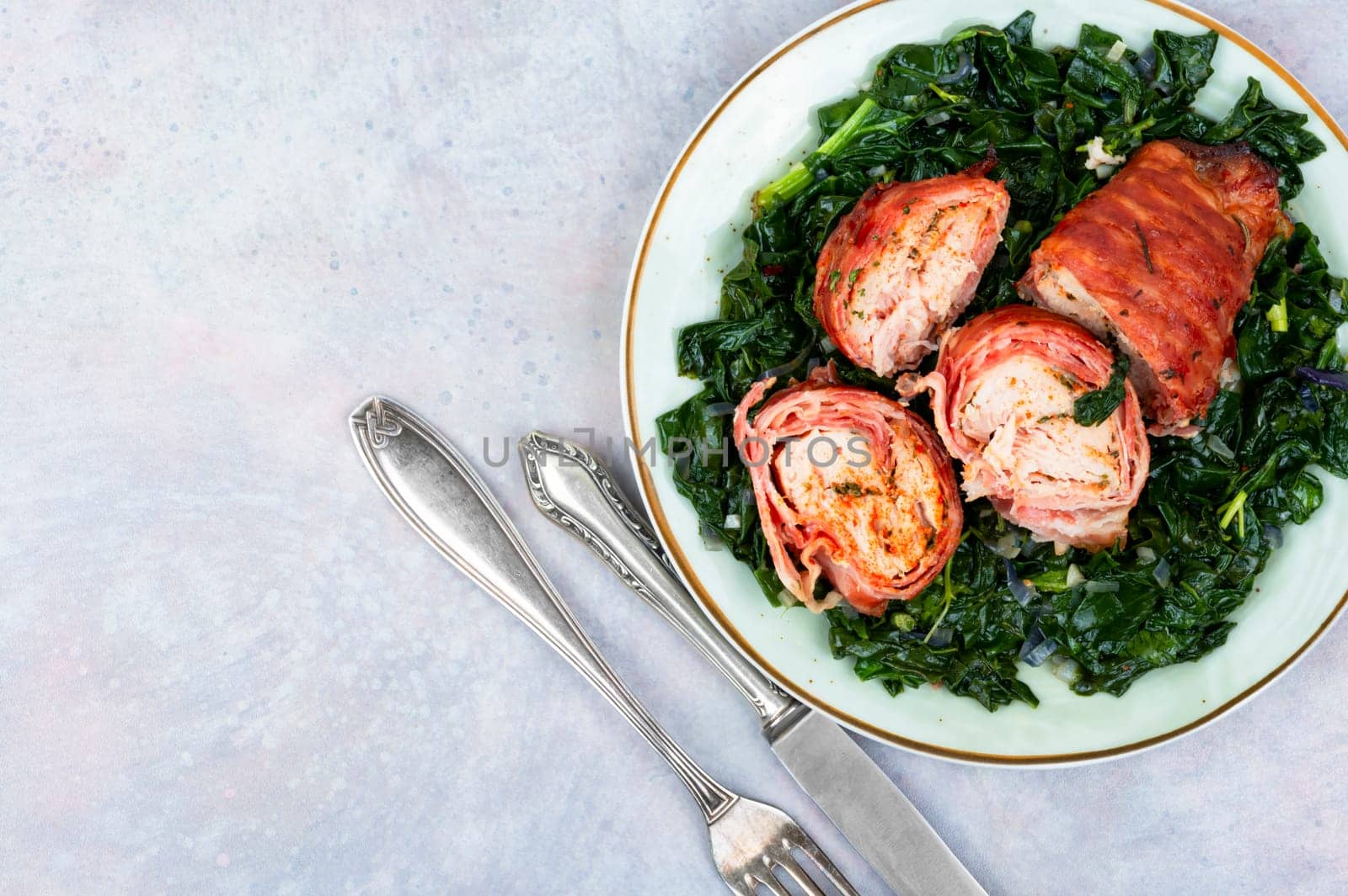 Grilled chicken fillet roll and fried spinach. Copy space