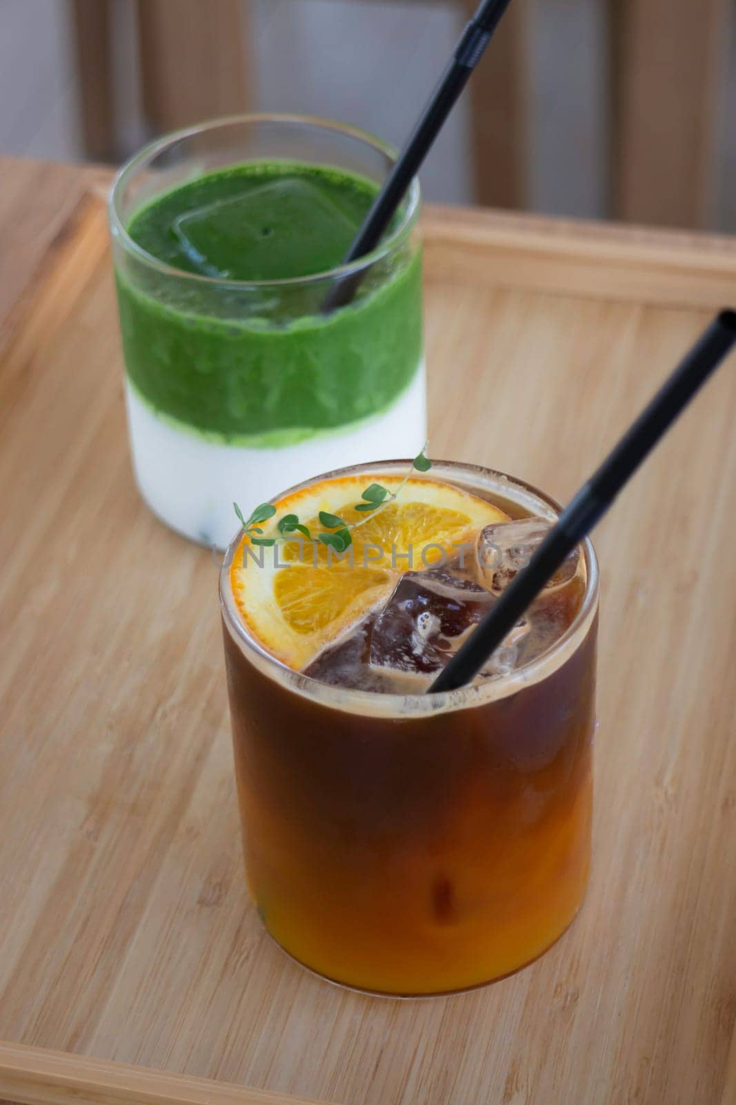 Iced matcha greentea and iced black orange coffee on wooden table, stock photo