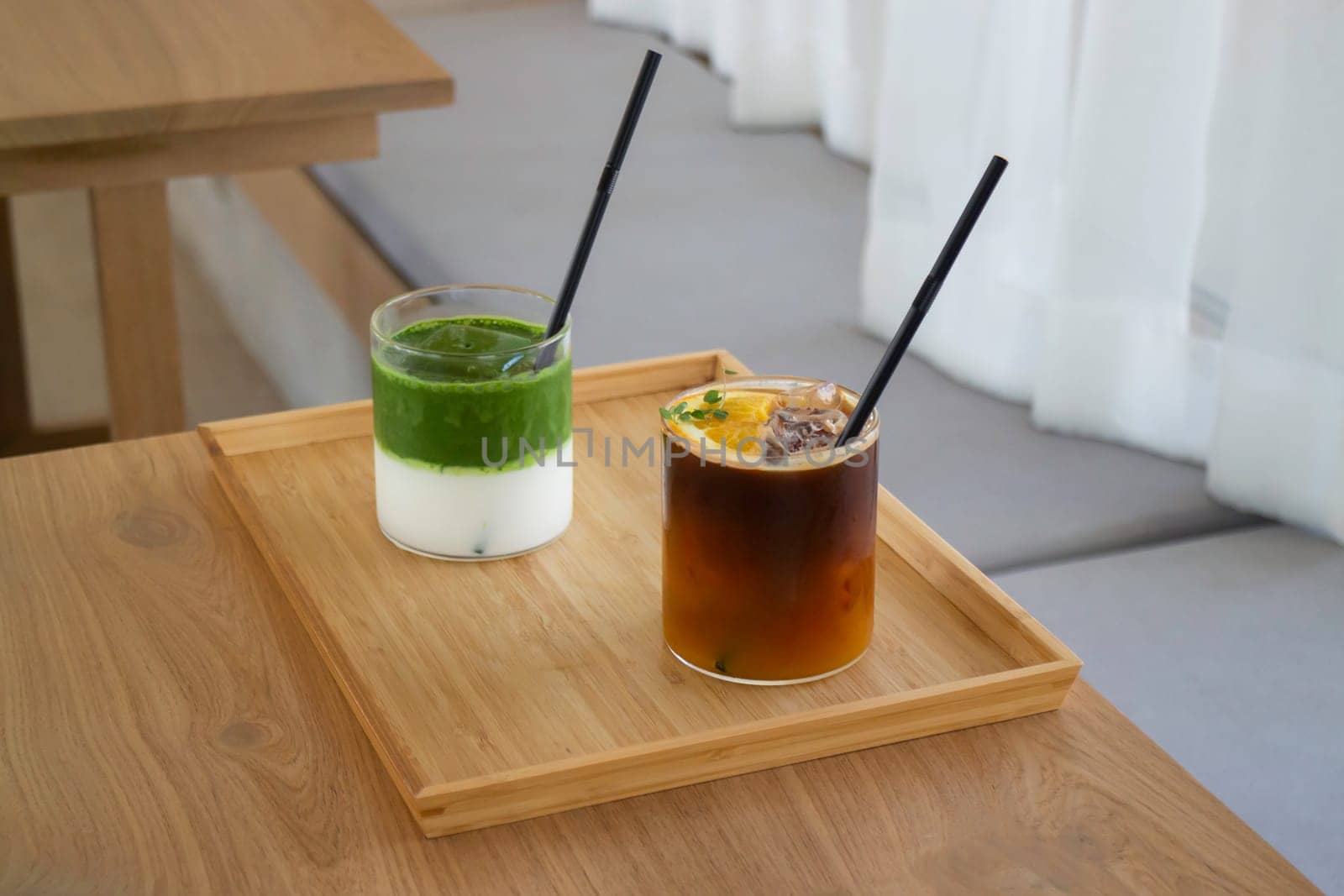 Iced matcha greentea and iced black orange coffee on wooden table, stock photo