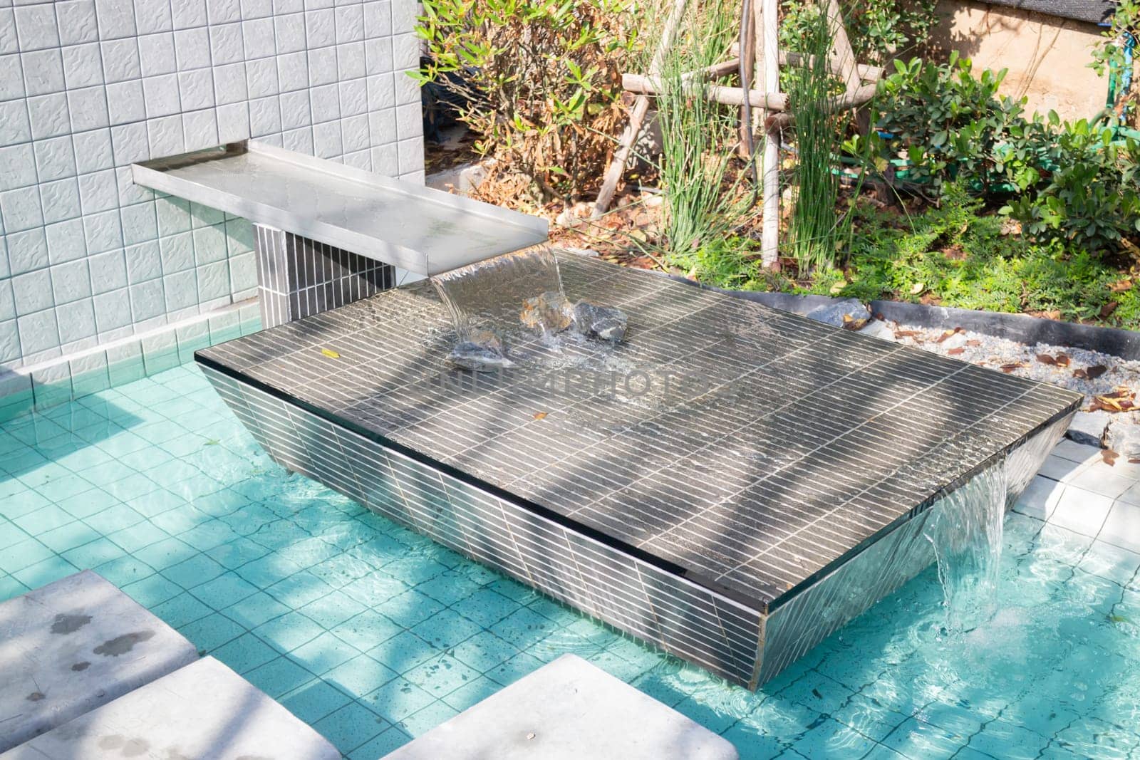 Mosaic in green transparent water at the bottom of the pool, stock photo