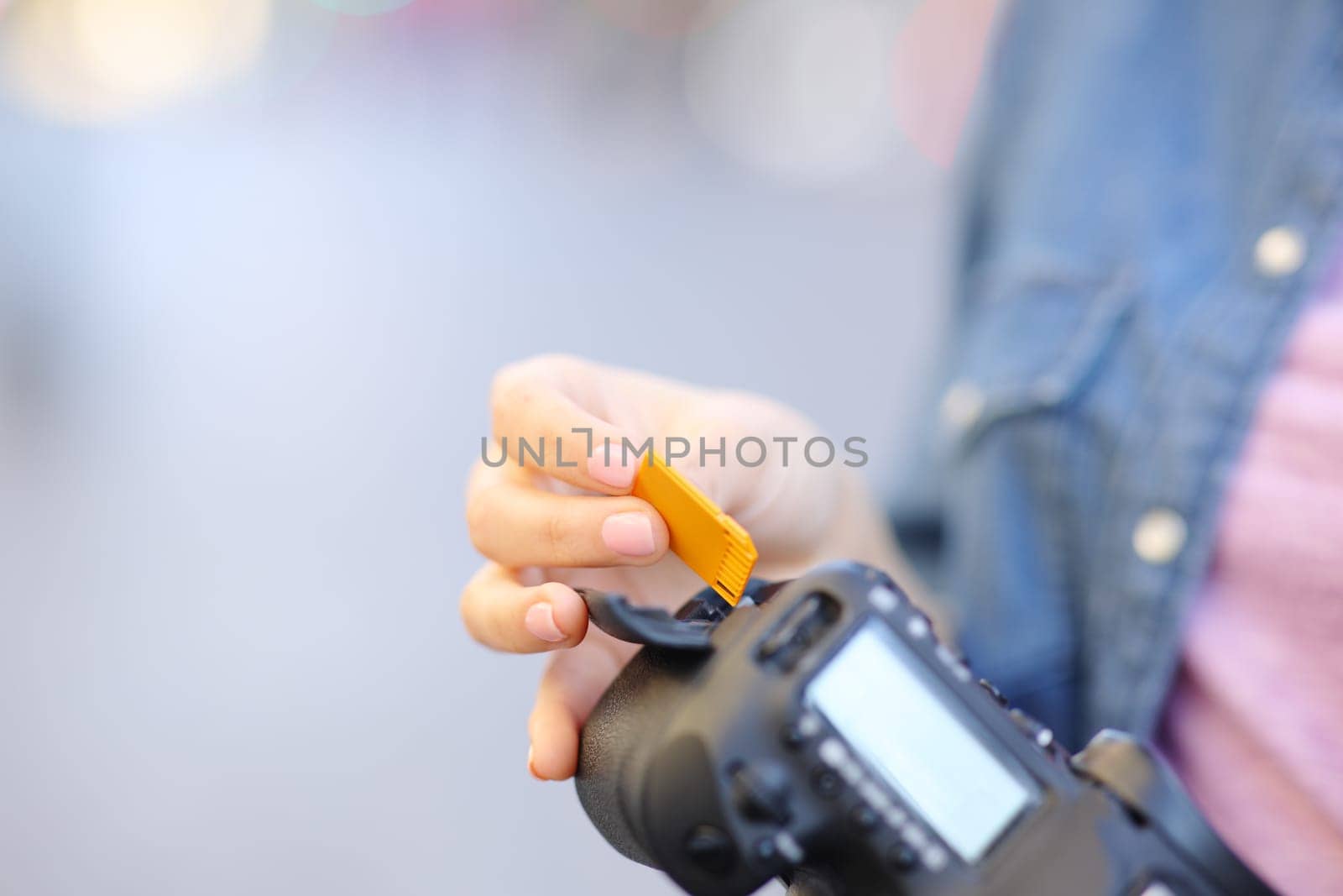 Close up of a photographer hand insterting sd card on camera in the street