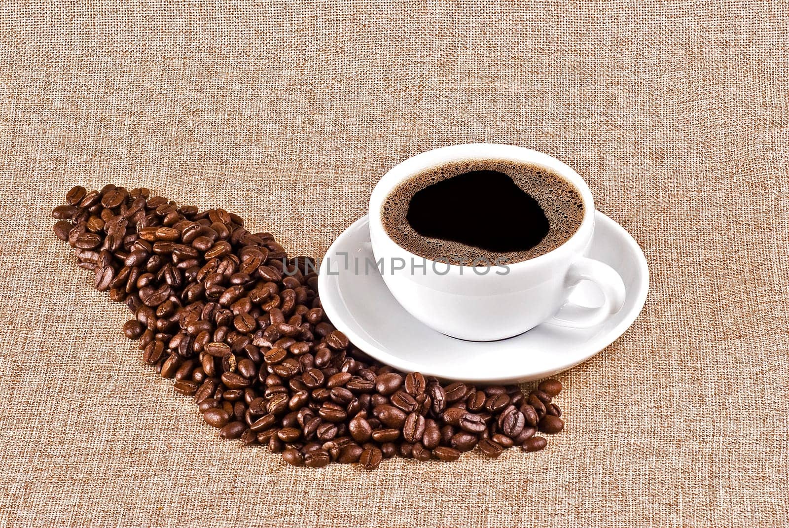 Cup of coffe and coffe beans on burlap background