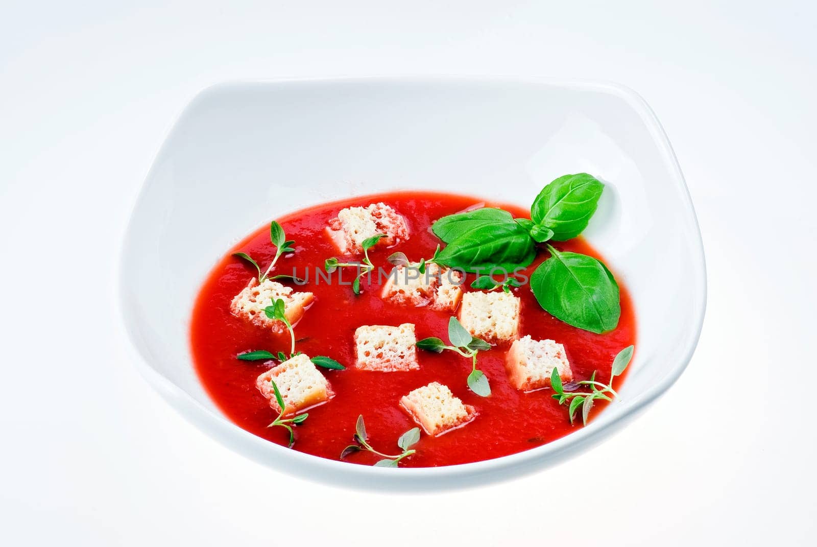 Bowl of tomato soup over white background