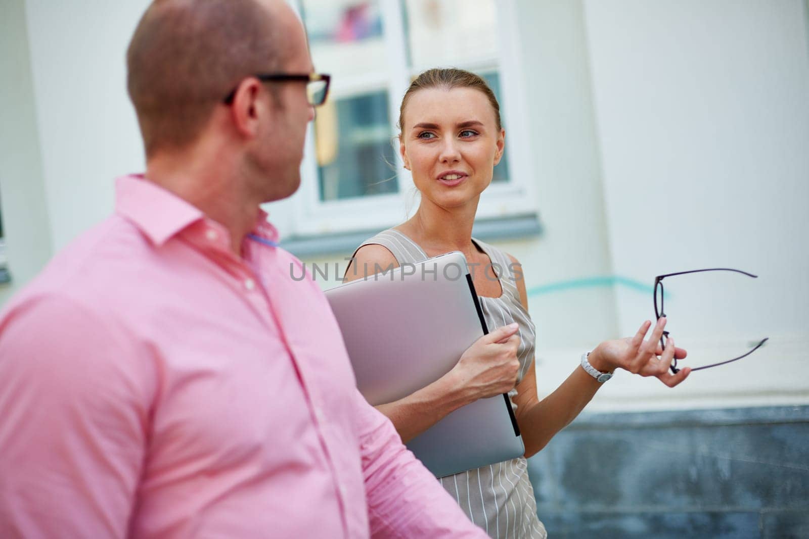 Young businesswoman looking at her colleague while talking to him