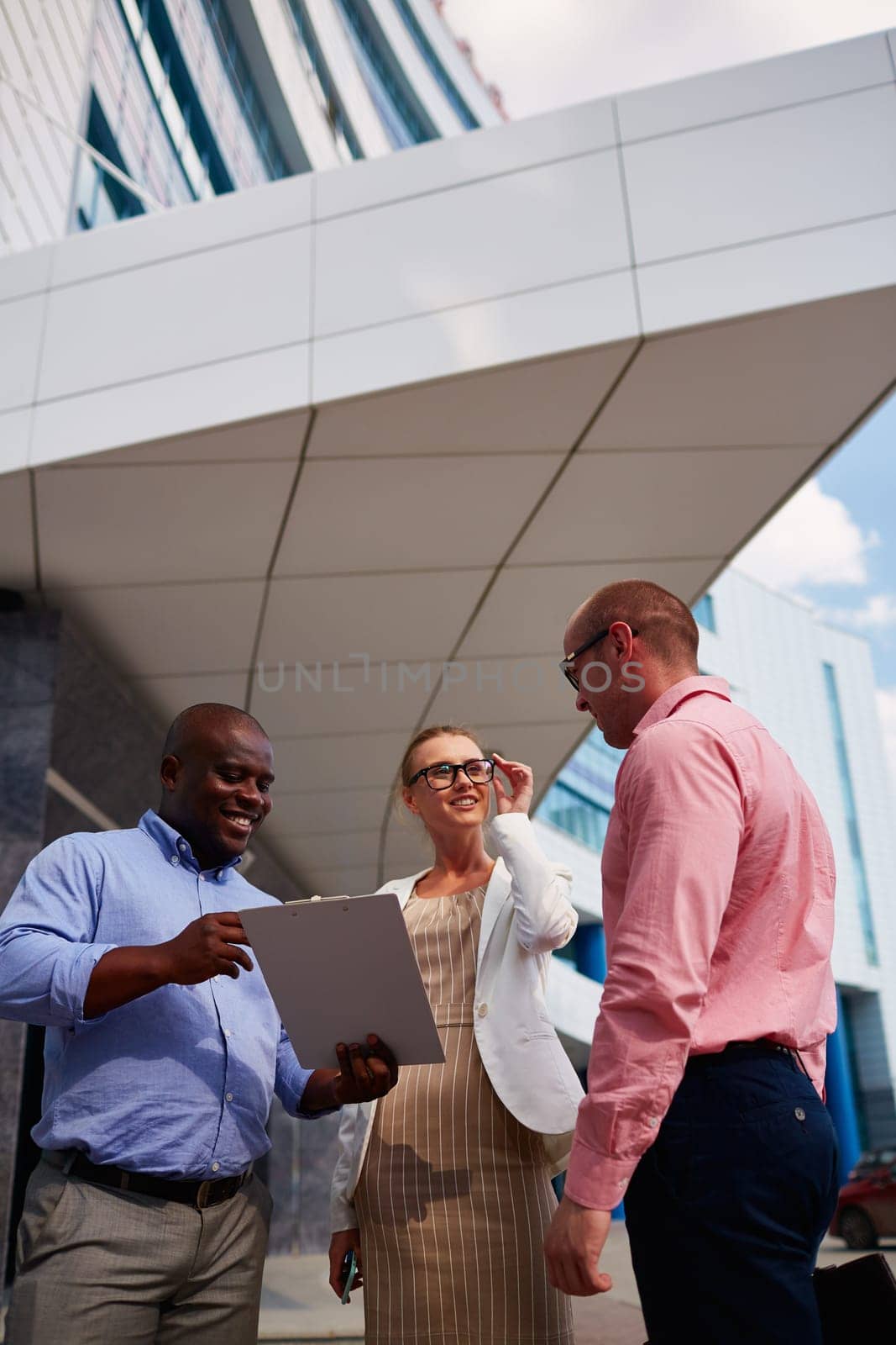 Business partners interacting by office building