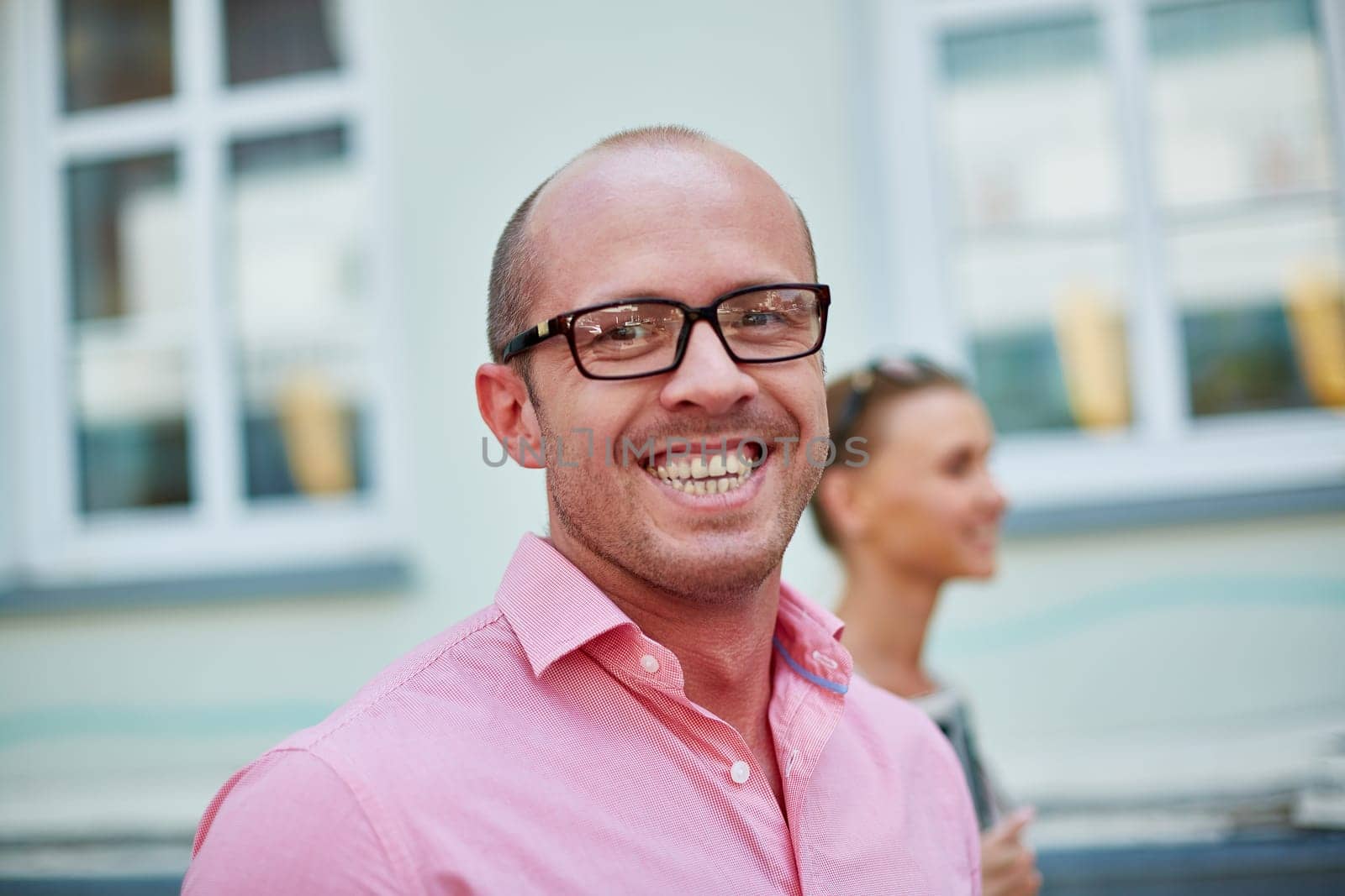 Young businessman in eyeglasses looking at camera with toothy smile