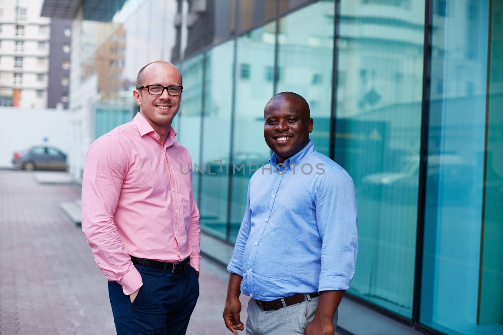 Two happy businessmen looking at camera in urban environment
