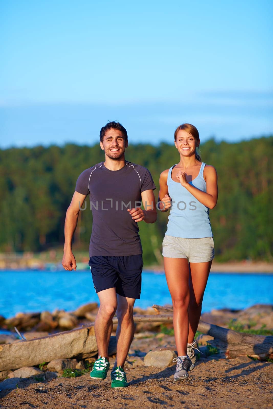 Young couple running down sandy beach