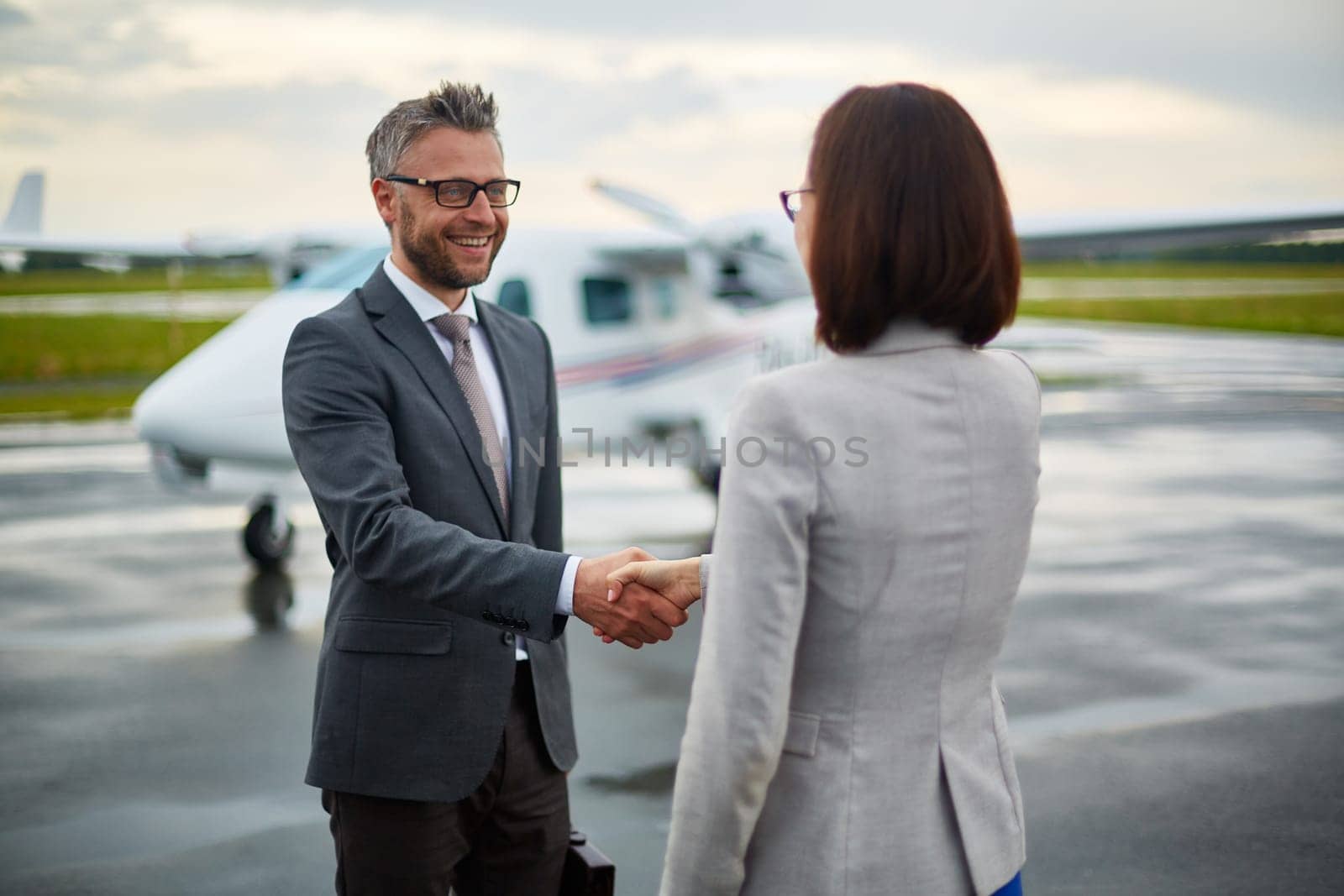 Happy businessman handshaking with his partner in airport