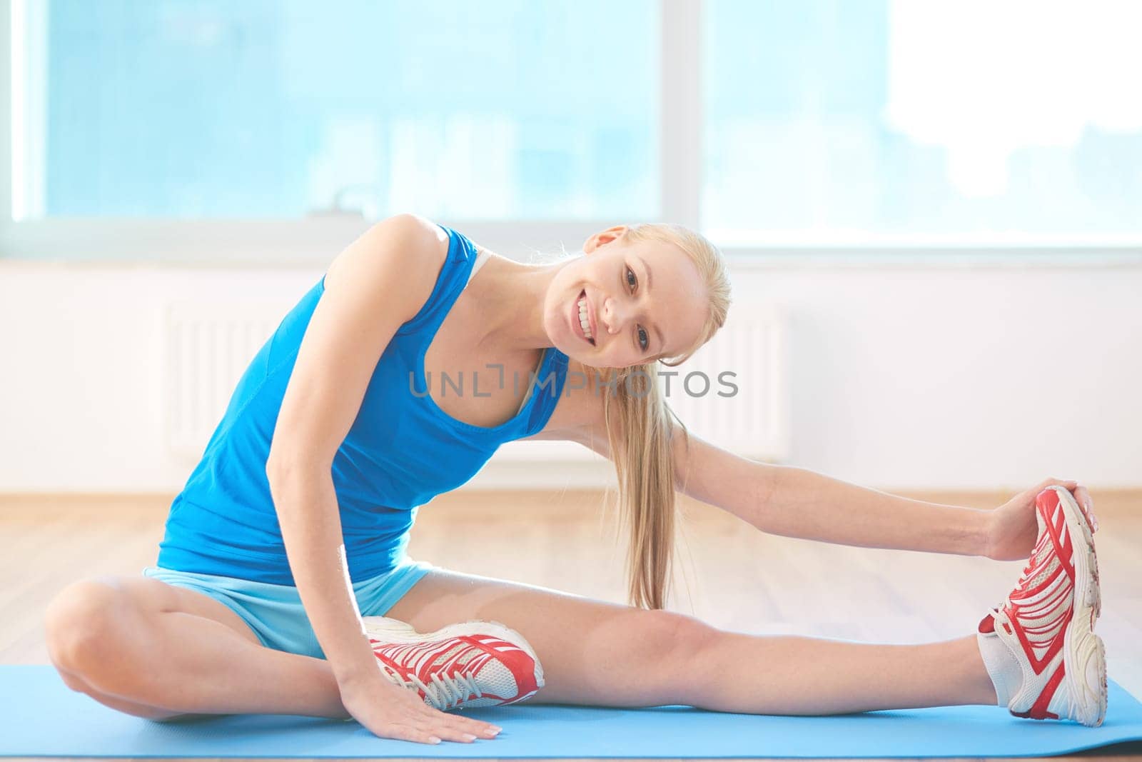 Fit woman looking at camera while exercising in gym