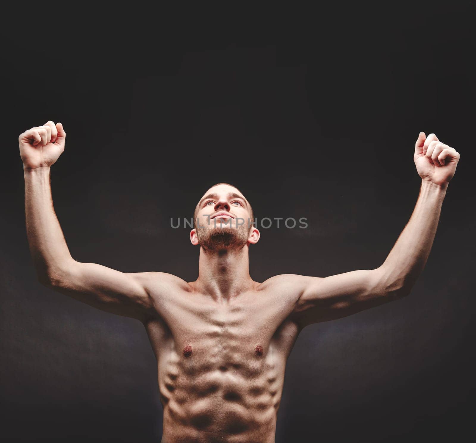 Young man with raised arms in isolation