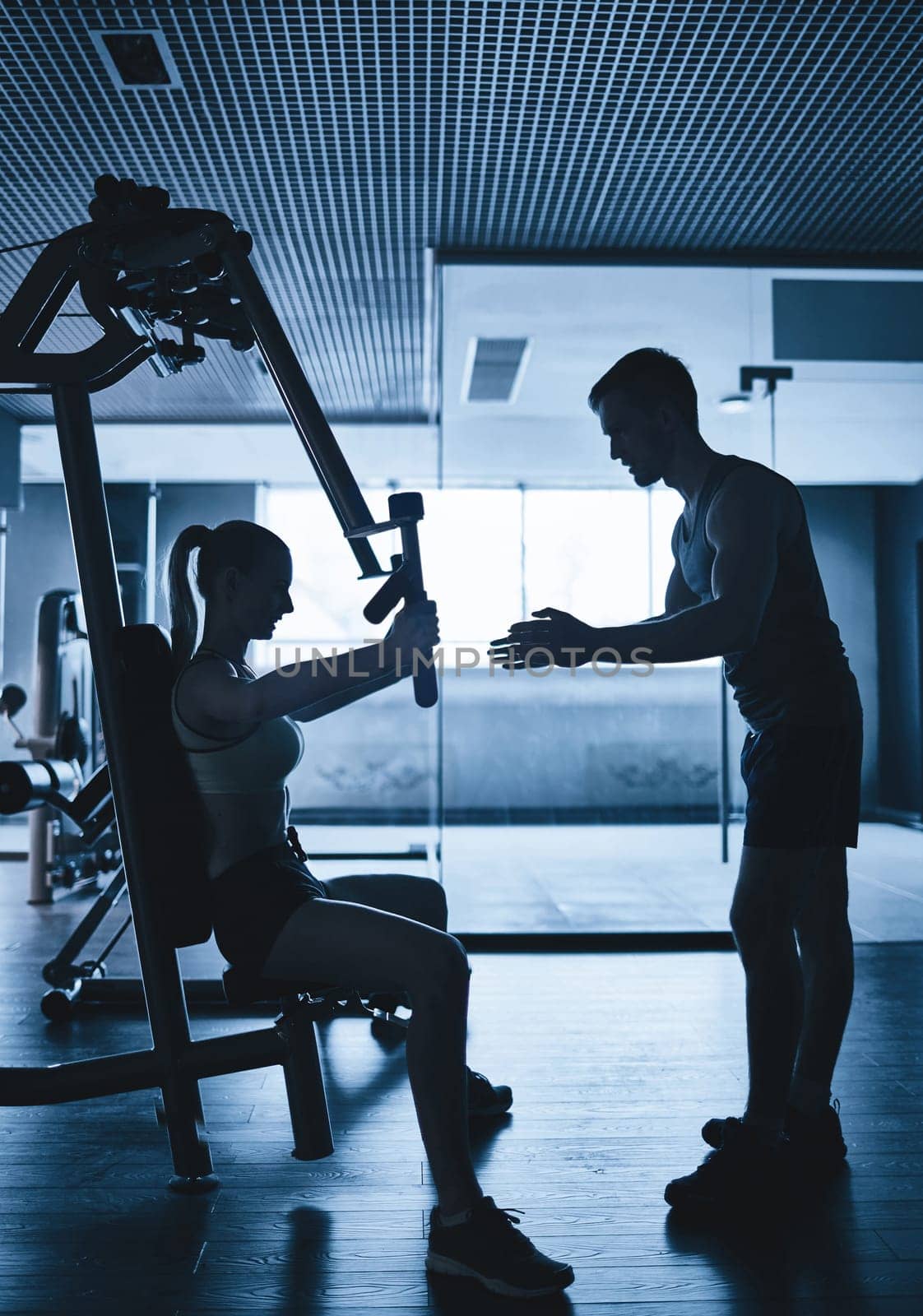 Outlines of active woman and coach in gym