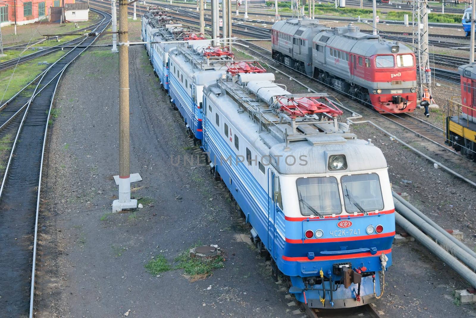 Electric type CHS2K-741 is on the tracks at a railway station. Top view of the front right side
